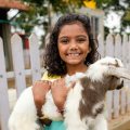A-child-carrying-a-lamb-at-Picket-Fence-family-farm